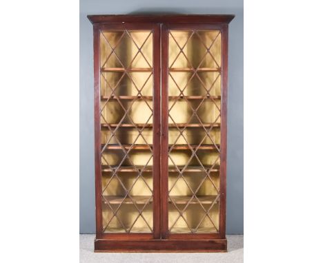 A Georgian Oak Bookcase, with moulded cornice, fitted six shelves enclosed by a pair of astragal glazed doors, on plinth base