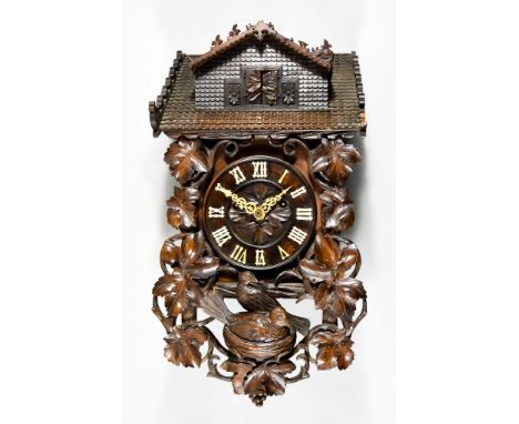 A 19th Century Carved and Stained Wood Black Forest Cuckoo Clock, with labels for Kamerer Cuss, Tritschler & Co., the 6.25ins