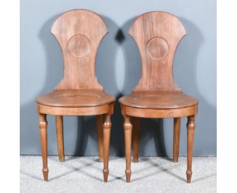 A Pair of George III Mahogany Hall Chairs, the shaped backs with moulded edges, matching wood seats inset with plain oval car