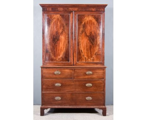 A George III Gentleman's Mahogany Wardrobe, the upper part with moulded cornice, fitted hanging rail enclosed by a pair of ov