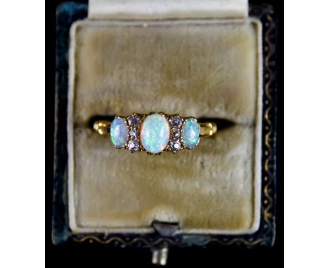 An 18ct Gold Three Stone Opal and Diamond Ring, set with three opals interspaced by six brilliant cut white diamonds, size M,