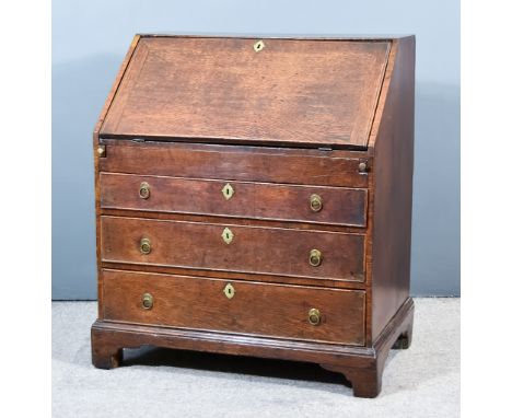 A George III Oak Bureau, the slope with brown leather and gilt tooled inset to fitted interior with well, pigeon holes and fo