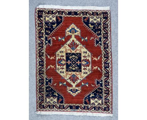 An Early 20th Century Kashkuli Rug woven in colours of fawn, navy blue and terracotta, with a bold central hexagonal medallio