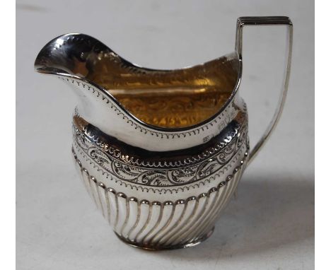 A late Victorian silver cream jug, of helmet shape and half-gadrooned form, having angular handle and gilt-washed interior, g