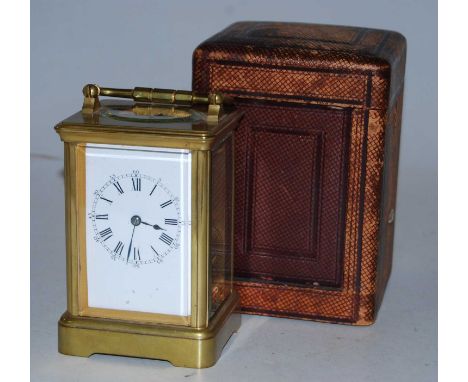 An early 20th century lacquered brass cased carriage clock having enamel dial with Roman numerals and Arabic outer scale with