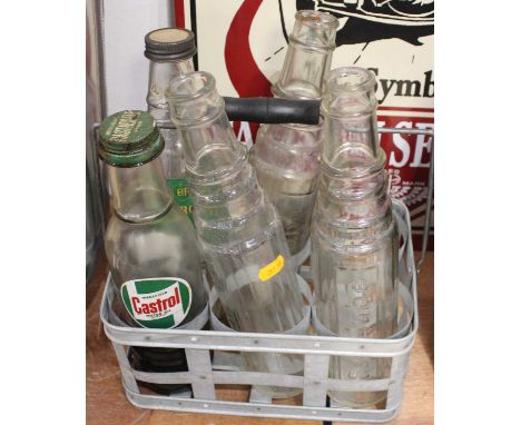An original six divison motor oil bottle holder containing five examples to include 3x Esso Lube, 1x Castrol Wakefield Motor 