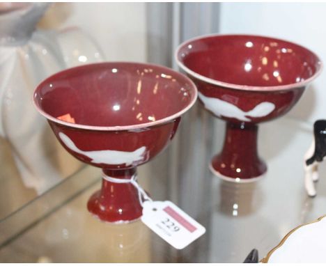 A pair of Chinese export stem cups, each on a deep red ground and having six character mark verso, h.9cmCondition report: One