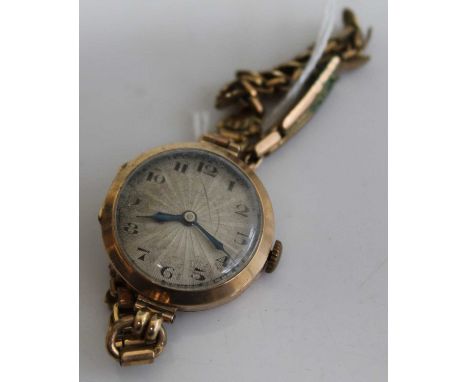 A ladies 9ct gold cased wrist watch having unsigned engine turned dial, manual wind movement and on gilt metal bracelet, case