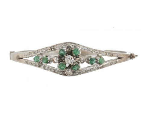 AN EMERALD AND DIAMOND BANGLE, the brilliant cut diamonds approx 0.6 ct, the emeralds approx 0.7 ct, in white gold, marked 18