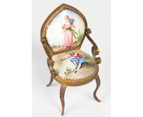 A CONTINENTAL MINIATURE GILTMETAL AND PAINTED ENAMEL CHAIR, THE BACK AND SEAT WITH THE FIGURES OF A YOUNG WOMAN OR YOUTH, 7CM