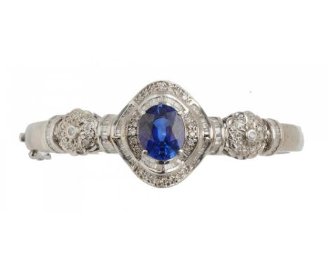 A SAPPHIRE AND DIAMOND BANGLE, the baguette and brilliant cut diamonds approx 1.5 ct, the oval faceted sapphire approx 5.5 ct