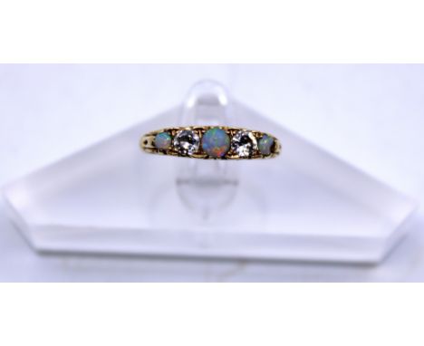 Vintage 18ct Yellow Gold Opal And Diamond Five Stone ring.  The ring contains three Opals and two Round Brilliant Cut Diamond