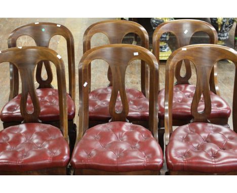 A set of six Victorian mahogany and red leather button upholstered cushioned chairs with scrolling front legs raised on pot c
