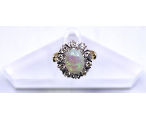 18ct Yellow Gold Opal and Diamond ring.  The Oval Cabochon Opal measures approx. 10mm x 8mm.  There is ten surrounding Round 