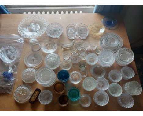 A large collection of pressed glass items, mainly candle tea light holders, varying colour ways, to include knife rests and o
