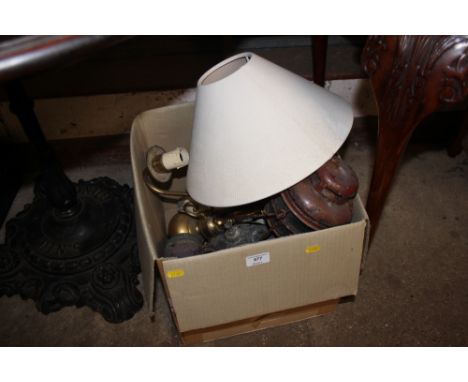 A box containing a Tilley lamp; one other lamp; a brass light fitting; and two clocks