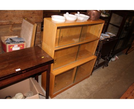 A Minty light oak three tier bookcase with sliding glass doors 