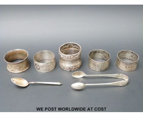 Five various silver hallmarked napkin rings, a pair of hallmarked silver sugar tongs and a guilloche enamel spoon mared 930S 