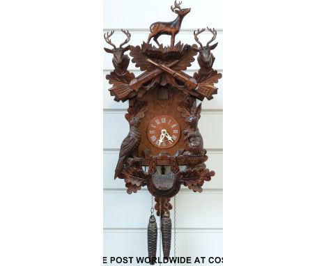 A c1980 Black Forest Cuckoo clock with hunting design, pheasant and hare decoration, on/off facility and instruction booklet