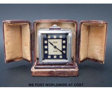 An Art Deco JAZ travel alarm, in original leather travel case, the clock movement Brevete, in chrome and bakelite case