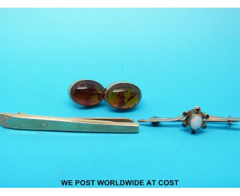 A pair of 9ct gold earrings set with pressed amber, a 9ct gold tie clip set with a diamond and a yellow metal brooch marked 9