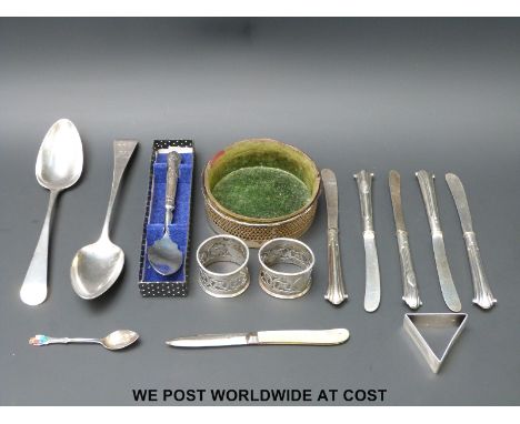 Two hallmarked silver table spoons, three hallmarked silver napkin rings,  a triangular napkin ring marked sterling and a sim