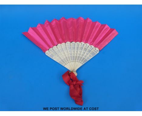 A 19thC bone folding hand fan with uniform pierced guard stick, pink silk leaves and mother of pearl mounted rivet, length 28