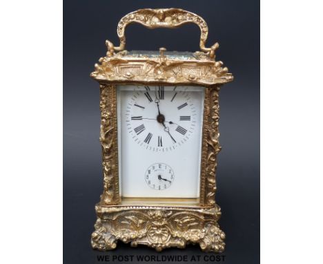 A French half hour repeater and alarm carriage clock in ornately decorated brass case, Roman numerals, seconds sweep