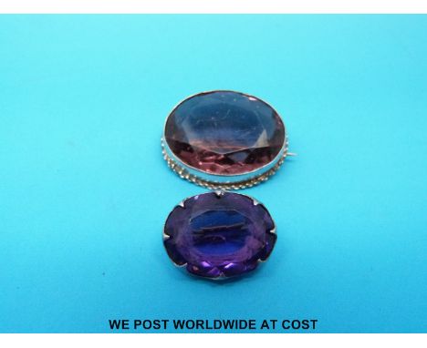 A silver brooch set with an amethyst by Charles Horner and another similar brooch