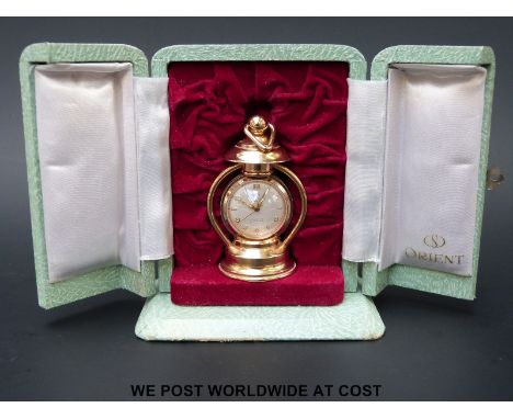 A small 17 jewelled Orient Star travelling clock in the form of a lamp, in green case
