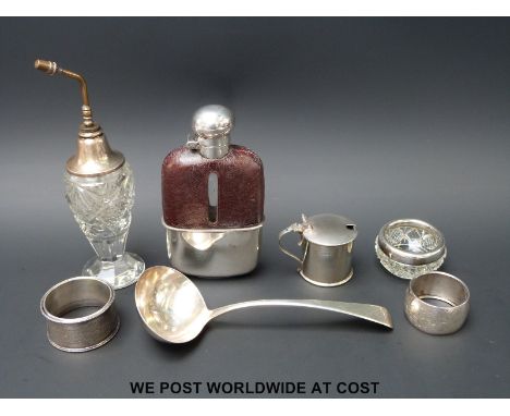 A Georgian hallmarked silver ladle, three silver napkin rings and a mustard, weight of silver 131g, together with an atomiser