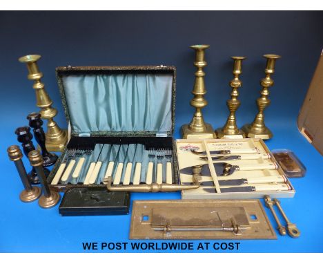 Three sets of brass candlesticks including ejector types, a pair of ebony examples, boxed cutlery sets, vintage darts etc