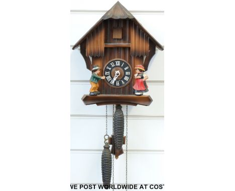 A German black forest cuckoo clock featuring a boy and girl figure