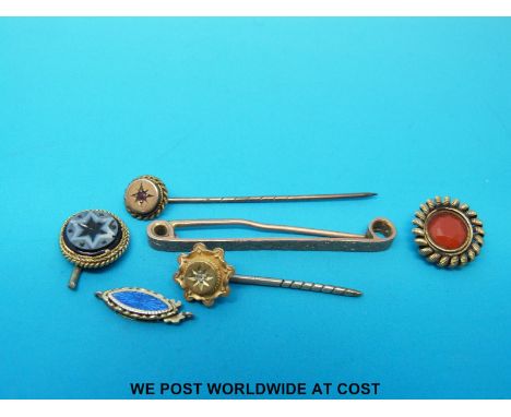 A 9ct gold stick pin set with a ruby, a 15ct gold stick pin set with a diamond, a yellow metal tie pin etc.