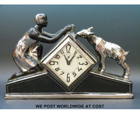 An Art Deco ceramic cased mantel clock timepiece with girl feeding a lamb to top, the diamond shaped dial with stylized hands