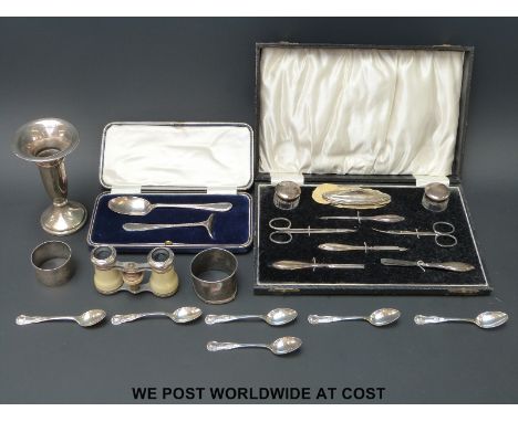 A cased hallmarked silver pusher and spoon set, a set of six hallmarked silver Kings pattern coffee spoons and a silver napki