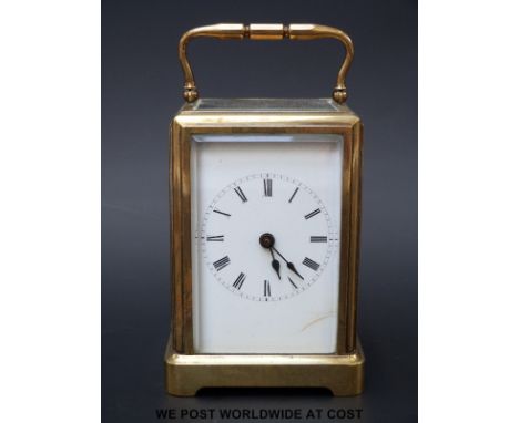 A brass cased carriage clock with bevelled glass panels