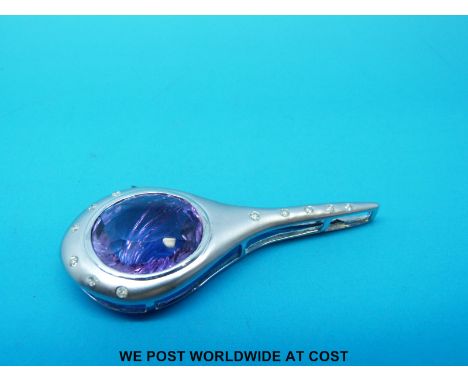 An 18ct white gold pendant in a curved design set with a central amethyst and diamonds to the edge 