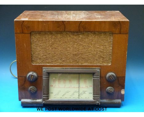 A model No.1113 medium and short mave c1950 radio in wooden case with bakelite dial surround. Ivorine name plate to back 'iss