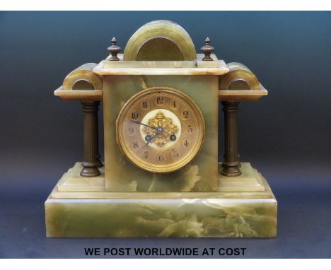 A 19th century onyx mantel clock, with brass columned decoration, brass coloured dial with peirced decoration over ivory colo