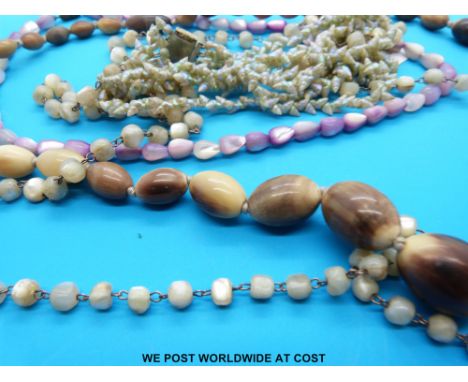 A necklace made up of graduated oval beads, a four strand necklace made up of miniature shells and two mother of pearl beaded