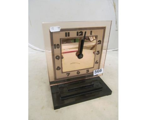 An Art Deco style clock pink glass and battery movementhas plastic base not bakelite and definately looks more modern