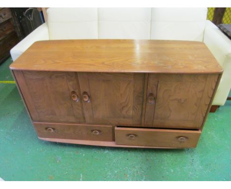 An Ercol sideboard three cupboard doors above two drawers