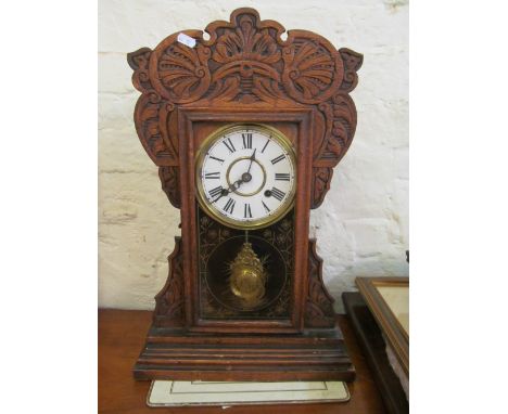 An American mantle clock in carved oak case with glass door revealing pendulum 53cms high