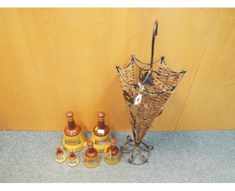An unusual umbrella stand and 6 empty Bells scotch whisky decanters (qty)