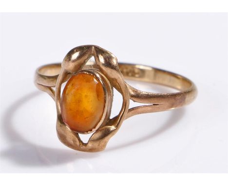 9 carat gold amber set ring, the oval amber held within leaf mounts