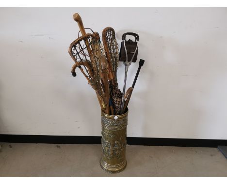 Embossed brass stick stand,  Together with an assortment of sticks, Lacrosse sticks. 