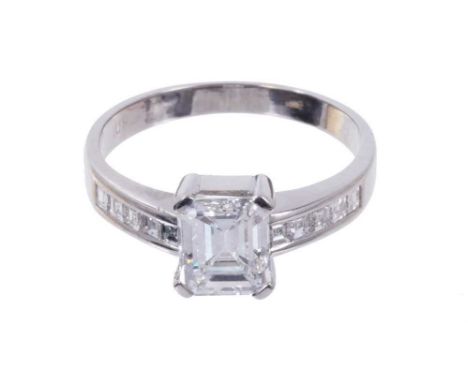 Diamond single stone ring with a step cut diamond weighing approximately 1.23 carats in four claw setting with further step c