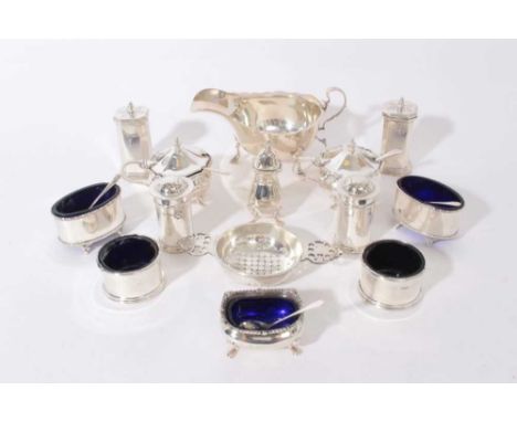 Group of silver condiments to include five salts with blue glass liners, two pairs of pepperettes, pair of silver mustard pot