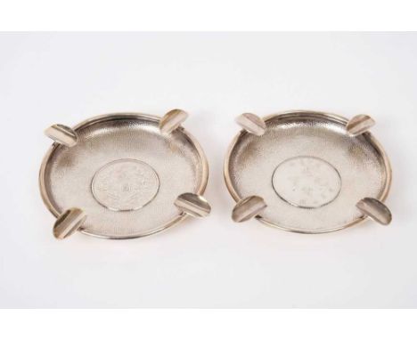 Pair of Chinese silver ashtrays of circular form set with coins on a planished ground, marked Y C Levy, Sterling, all at appr